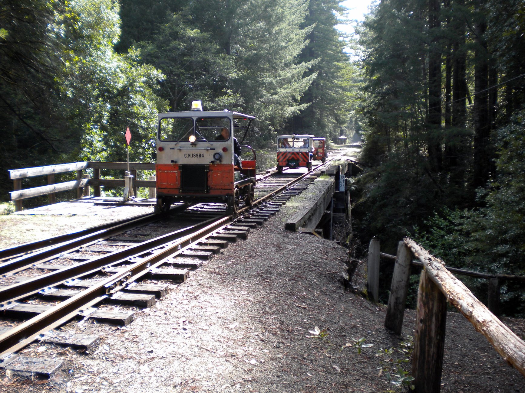 Railcars crossing a rustic bridge on the Niles Canyon Railway